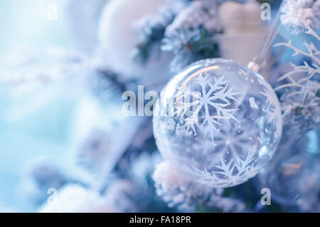 Beautiful Christmas decoration, transparent ball with snowflake decoration hanging on festive fir tree, happy winter holidays Stock Photo