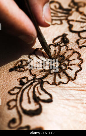Henna tattoo drawing with herbal dye on foot floral design macro closeup Stock Photo