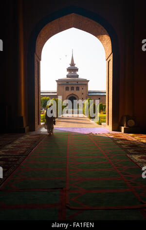 Muslim man walks through a large open arch doorway leading to the Main Mosque, Jama Masjid Stock Photo