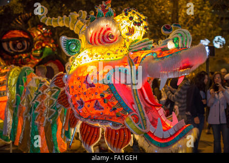 Illuminated dragon at San Francisco Chinese New Year night parade, with woman in background taking picture. Stock Photo