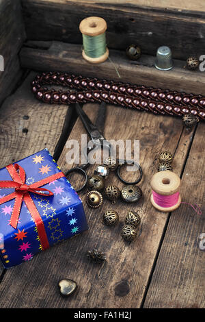 Old scissors,spools of thread,buttons and beads on wooden table Stock Photo