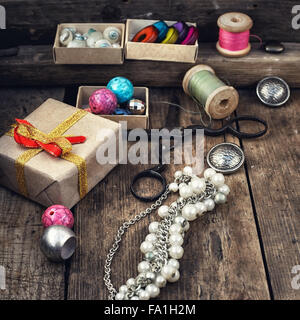 Old scissors,spools of thread,buttons and beads on wooden table Stock Photo