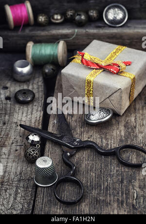 Old scissors,spools of thread,buttons and beads on wooden table Stock Photo