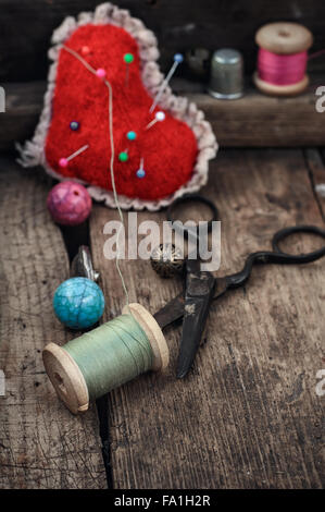 Old scissors,spools of thread,buttons and beads on wooden table Stock Photo