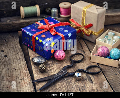 Old scissors,spools of thread,buttons and beads on wooden table Stock Photo