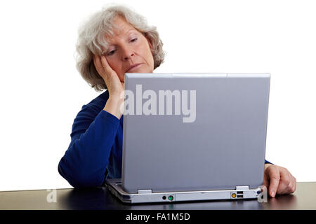 Old woman looking bored at her laptop Stock Photo
