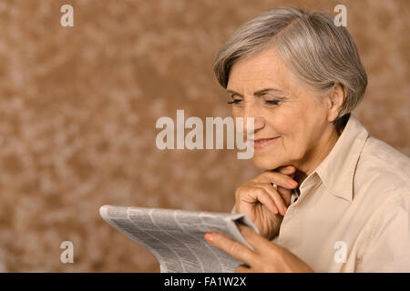 Aged woman reading newspaper Stock Photo