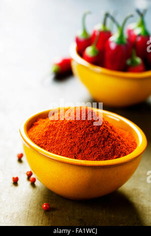 Paprika in a bowl and hot chili peppers on vintage background Stock Photo
