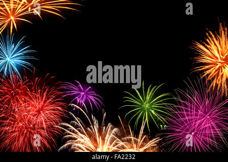 Joyful multi-colored fireworks as a frame with black copyspace in the background, ideal for New Year or other celebration events Stock Photo