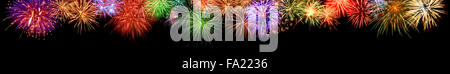 Gorgeous multi-colored fireworks as an extra wide panoramic border on black background, ideal for New Year or other celebration Stock Photo