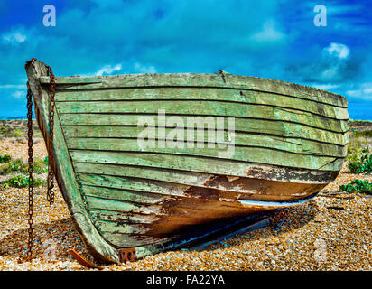 Old wooden fishing boat on a pebble beach. Stock Photo
