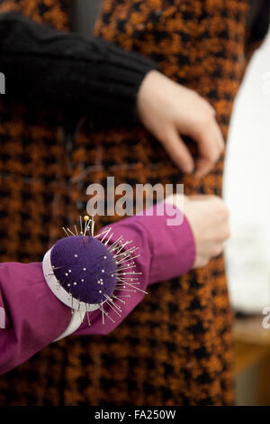 Custom tailor and her pincushion. Stock Photo