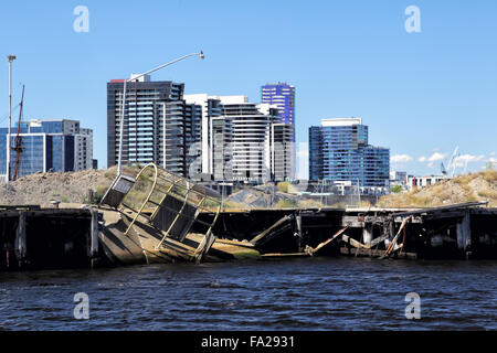 Modern high-rise buildings behind a run-down stretch of river bank of the Yarra River in Melbourne, Victoria, Australia, on a su Stock Photo