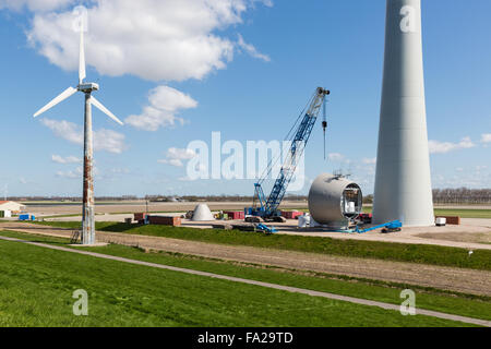 Dutch farmland with replacement of old wind tubines through enormous new wind turbines Stock Photo