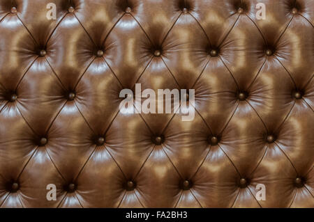 Fragment of brown leather backrest upholstery quilted buttons. Stock Photo