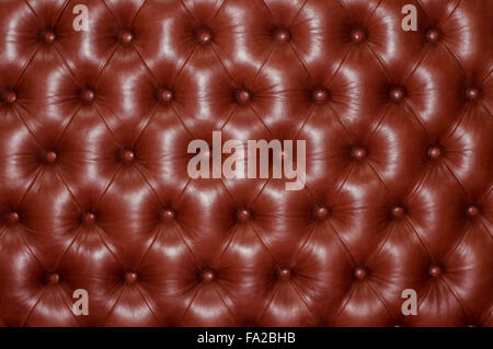 Fragment of brown leather backrest upholstery quilted buttons. Stock Photo