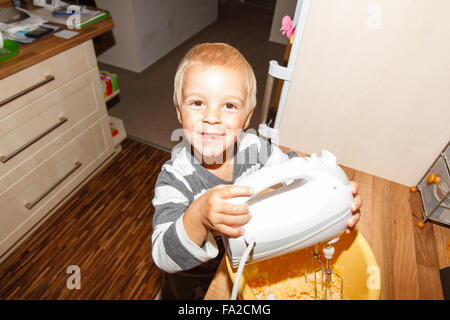 Little boy helping in the kitchen while cooking. Stock Photo