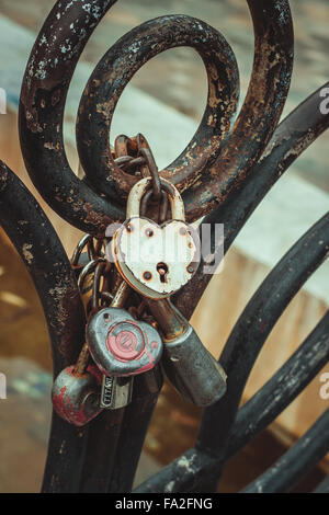 Old rusted wedding locks on the railing of the bridge. Stock Photo