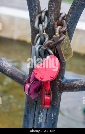 Bright wedding locks on the railing of the bridge. Stock Photo