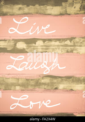 Concept image of Live Laugh Love motivational quote hand written on vintage painted wooden wall Stock Photo