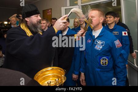 A Russian Orthodox priest blesses Expedition 46 Flight Engineer Tim Kopra of NASA at the Cosmonaut Hotel prior to his launch aboard the Soyuz TMA-19M December 15, 2015 in Baikonur, Kazakhstan. The Expedition 46 crew including Soyuz Commander Yuri Malenchenko, American astronaut Tim Kopra and Britain Tim Peake of ESA will launch to the International Space Station for a six-month stay. Stock Photo