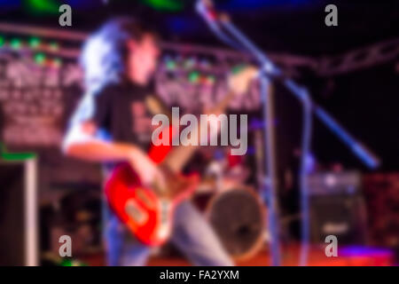 Defocused blur of rock guitarist with long hair performing Stock Photo