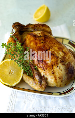Roasted whole chicken stuffed with chestnuts and mushrooms on white tablecloth Stock Photo