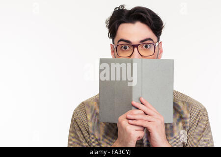 Portrait of a young man covering his face with book isolated on a white background Stock Photo