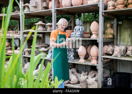 Male gardener checking inventory with digital tablet in garden centre, Augsburg, Bavaria, Germany Stock Photo