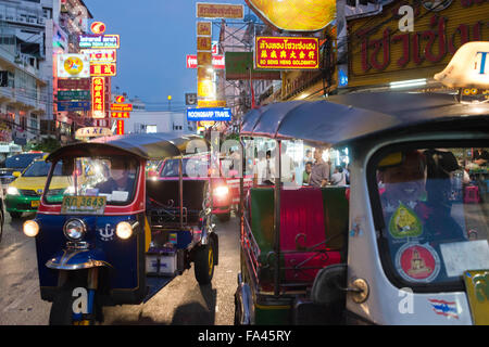 Tuk tuks taxi in the street. View down Thanon Yaowarat road at night in central Chinatown district of Bangkok Thailand. Yaowarat Stock Photo