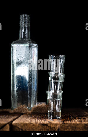 Pile of empty shot glasses (close-up shot) on wooden background Stock Photo