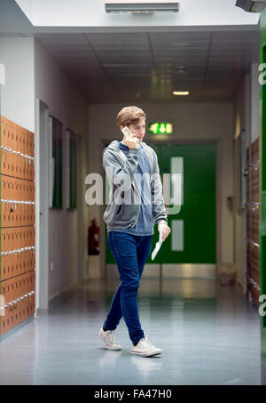 A teenage boy phones home with his results on ‘A’-Level results day at Abbeywood Community School, Bristol UK Stock Photo