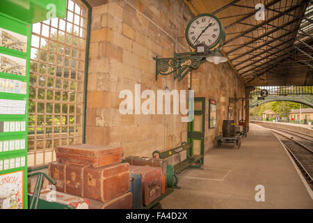 A view of the railway station platform at Pickering,North Yorkshire,England,UK featuring old style trolley,suitcases and benches Stock Photo