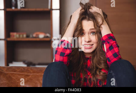Portrait of a stressed woman sitting on the sofa at home Stock Photo