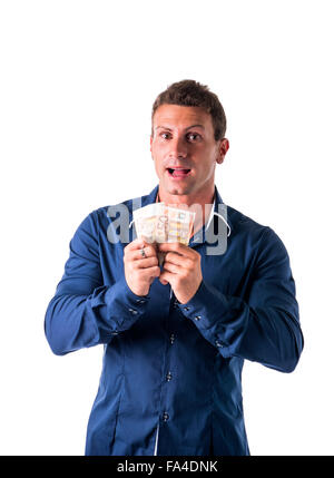 Young man holding two bank notes. Isolated, studio shot Stock Photo