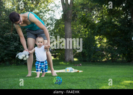 Mother helping her baby boy to take first steps, Munich, Bavaria, Germany Stock Photo