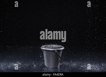 Bucket with water drops on dark background Stock Photo