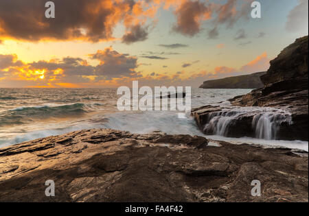 The setting sun over Trebarwith Strand in North Cornwall Stock Photo