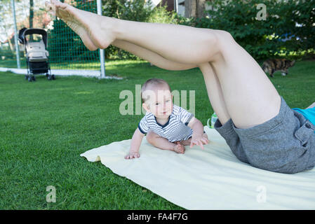 Baby boy playing around with his mother in lawn, Munich, Bavaria, Germany Stock Photo