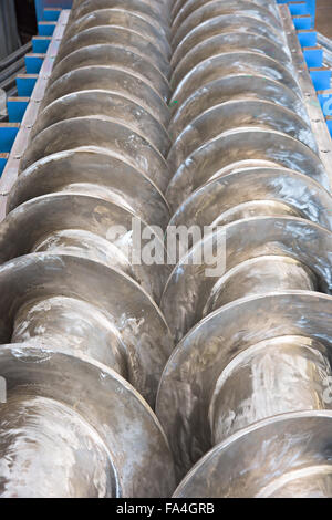 Industrial twin screw press for processing of waste from meat production, with the covers open. Shallow depth of field. Stock Photo