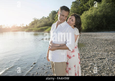 Mature couple romancing at lakeside and smiling, Bavaria, Germany Stock Photo