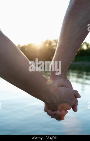 Close-up of couple in love holding hands during sunset, Bavaria, Germany Stock Photo