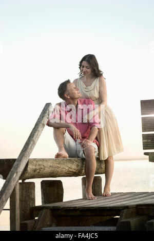 Mature couple looking at each other and smiling on pier, Bavaria, Germany Stock Photo