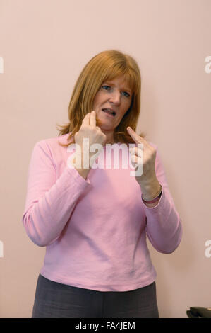 Single parent using sign language in her office, Stock Photo