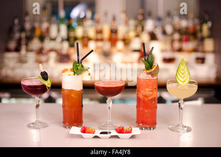 A range of cocktails displayed in front of a bar. Stock Photo