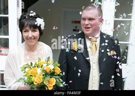 Bride and groom being showered with confetti after taking marriage vows at a registry office wedding, Stock Photo