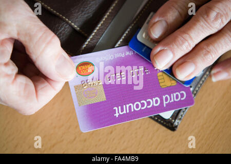 Older woman taking a post office account card out of her purse, Stock Photo
