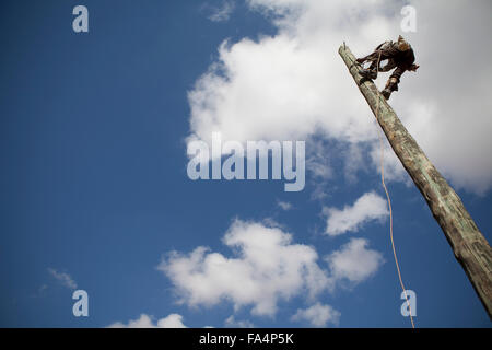 A worker strings new power cables in a rural village near Dodoma, Tanzania, East Africa. Stock Photo