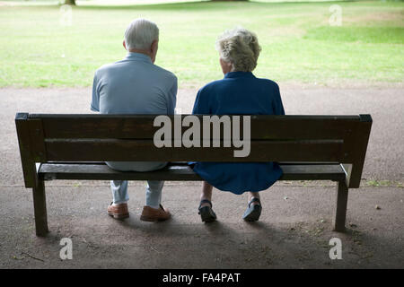 Older couple sitting on a bench in the park, Stock Photo