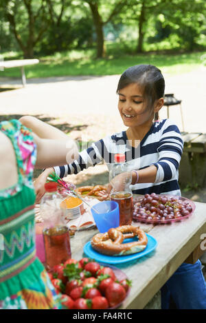 Girl eating food and smiling at picnic, Munich, Bavaria, Germany